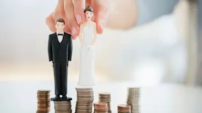 Muñecos de novios sobre pilas de monedas que representan el costo de casarse