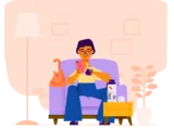 Mujer sentada en su sillón junto a su gato, mirando el celular.