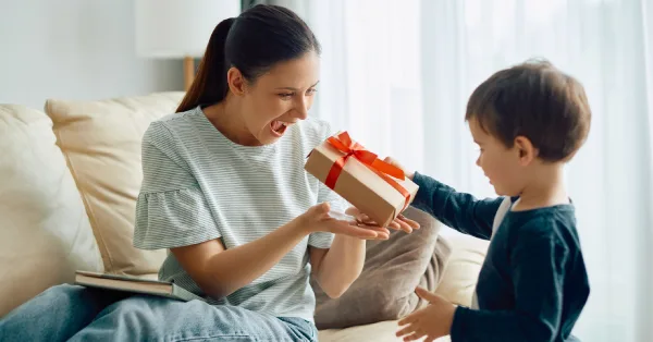 Madre con un libro recibiendo un regalo de su hijo