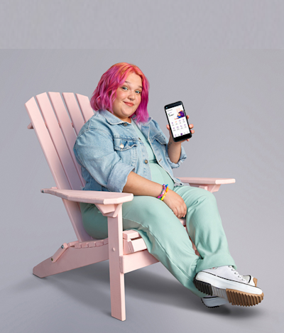 Joven muestra un teléfono celular en el que se ve la app Naranja X en la pantalla. 