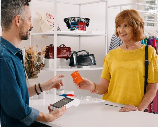 Mujer pagando con tarjeta Naranja X.