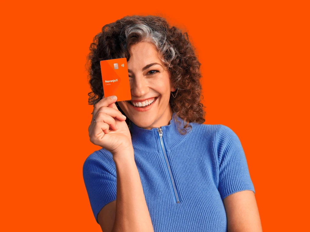 Mujer mostrando su tarjeta Naranja X.