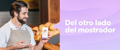 Un hombre trabajando en un negocio que muestra la app desde su celular