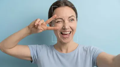Mujer sonriente se saca una selfie con marcas de reconocimiento facial en la cara