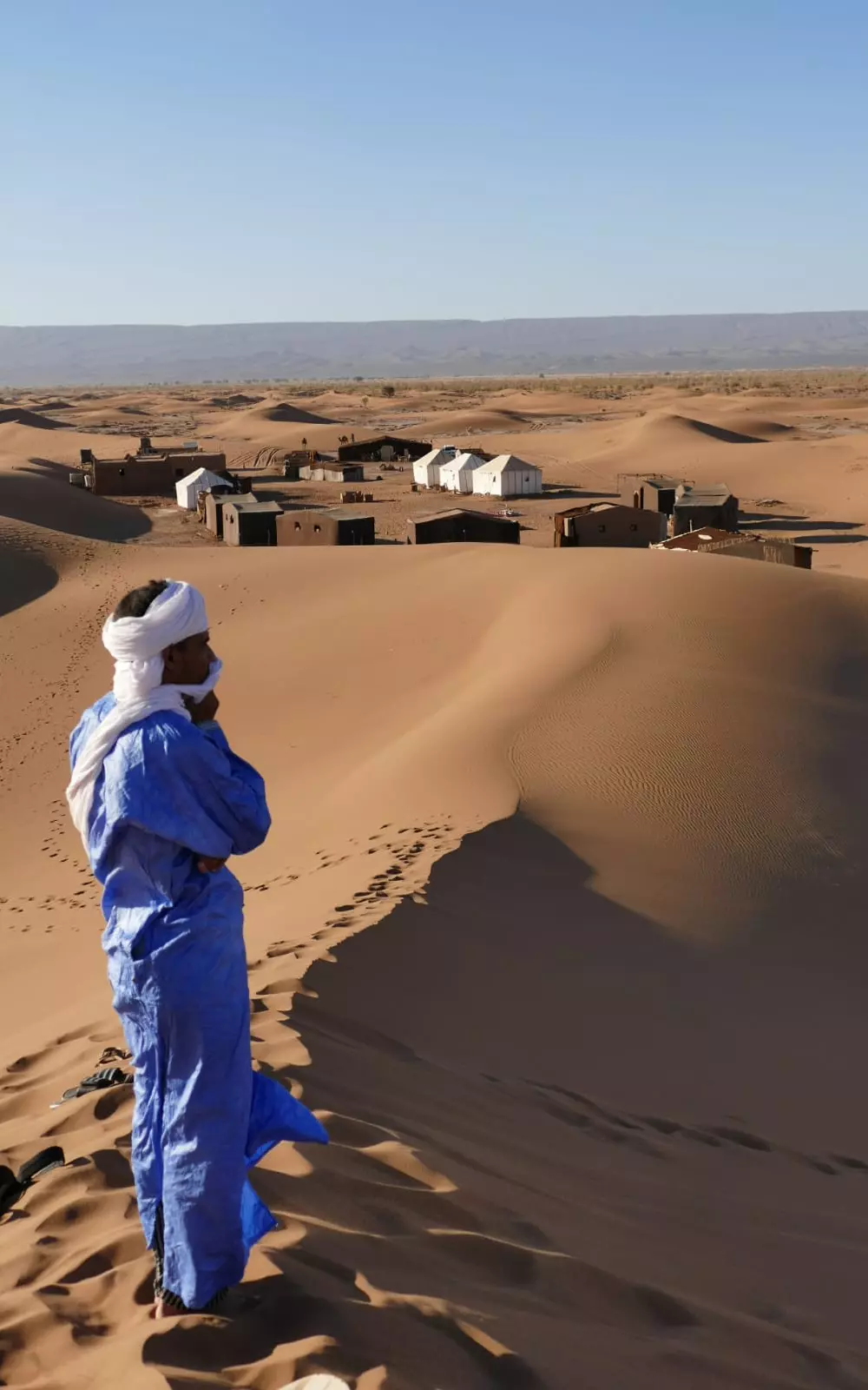 Aziz looking over houses in the desert