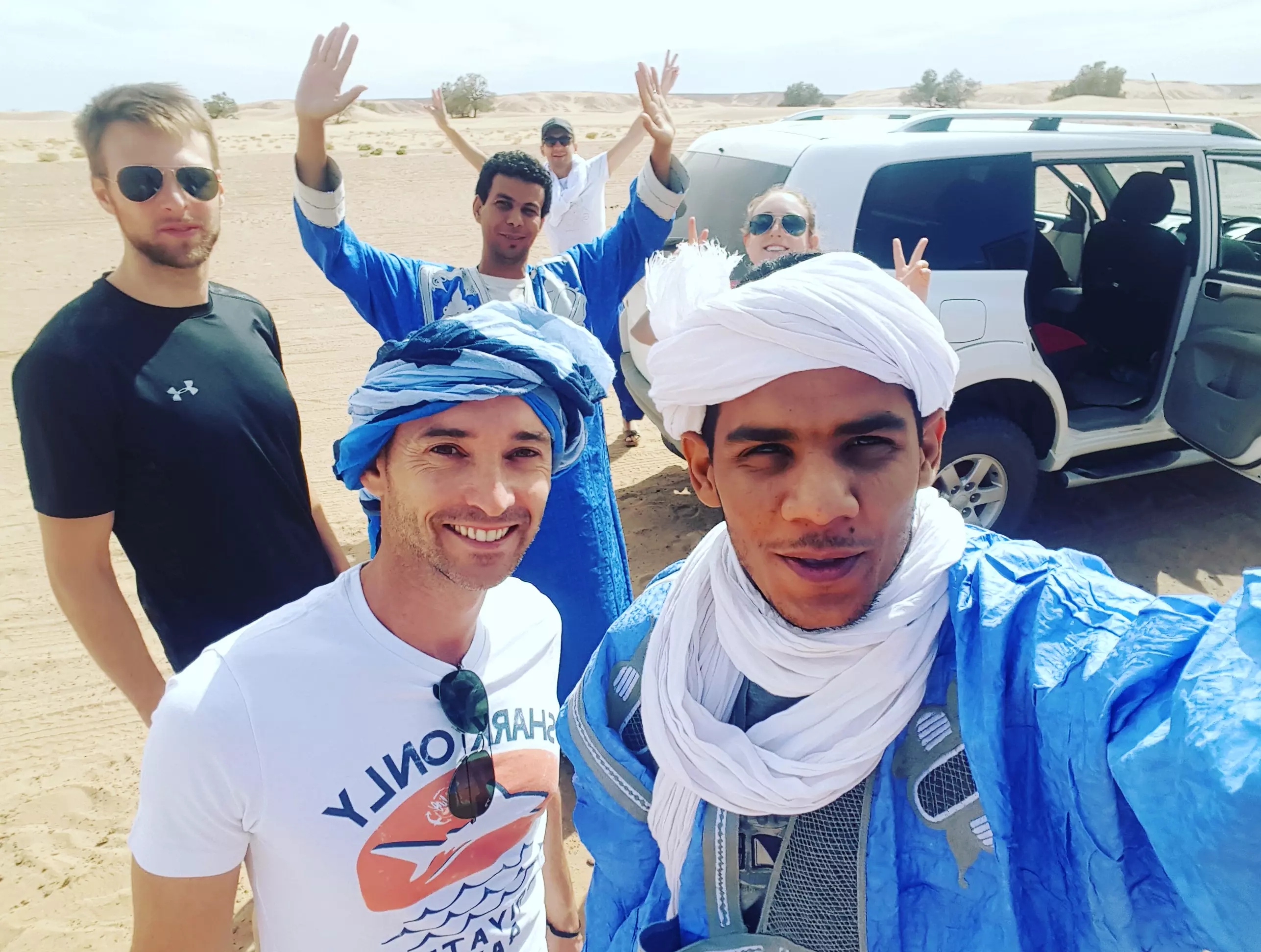 Aziz with friends in front of car