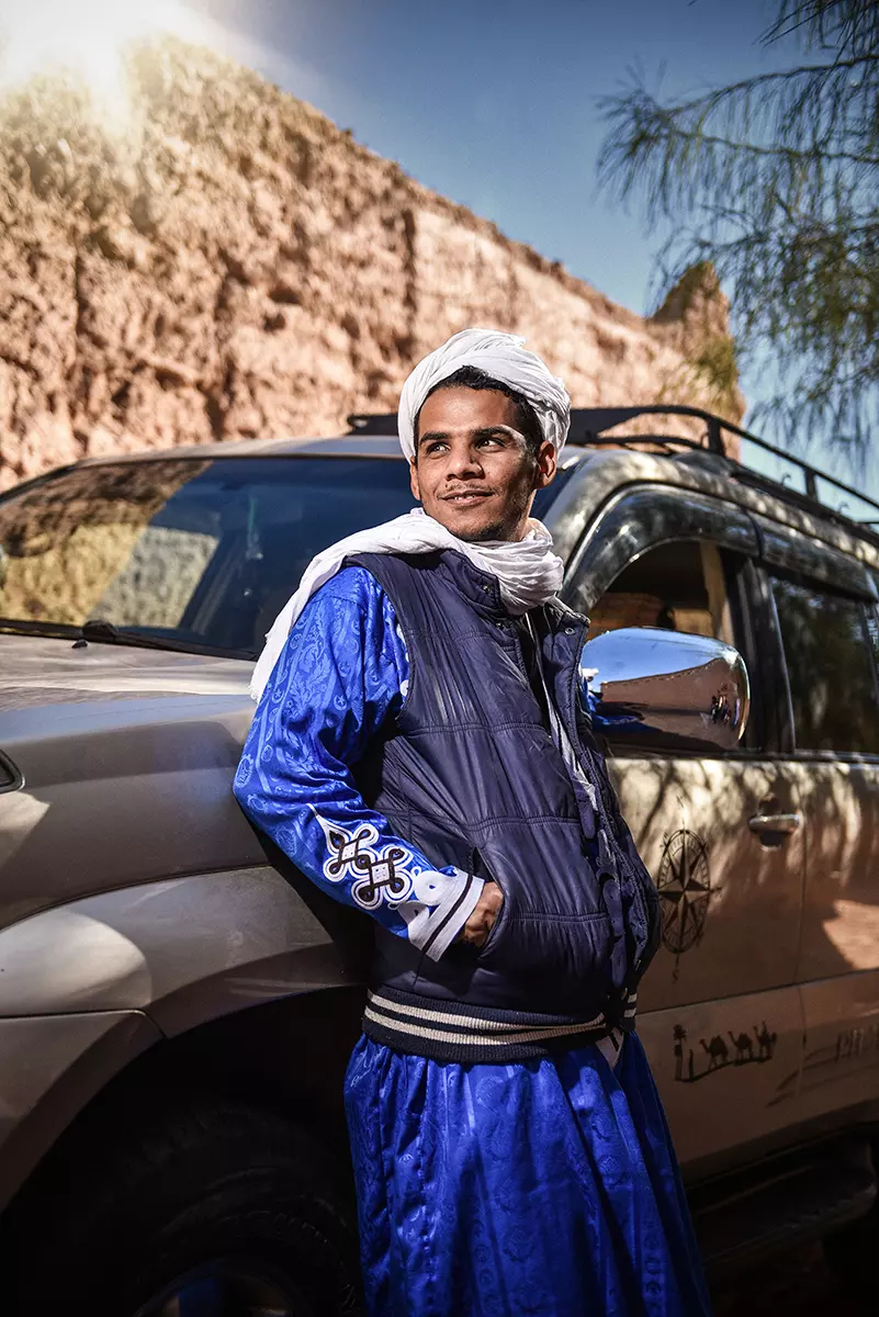 Aziz in front of a car