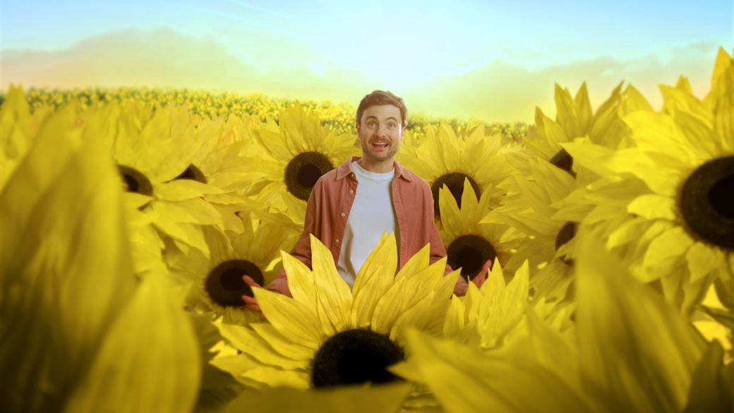Phil Laude steht in einem Sonnenblumenfeld