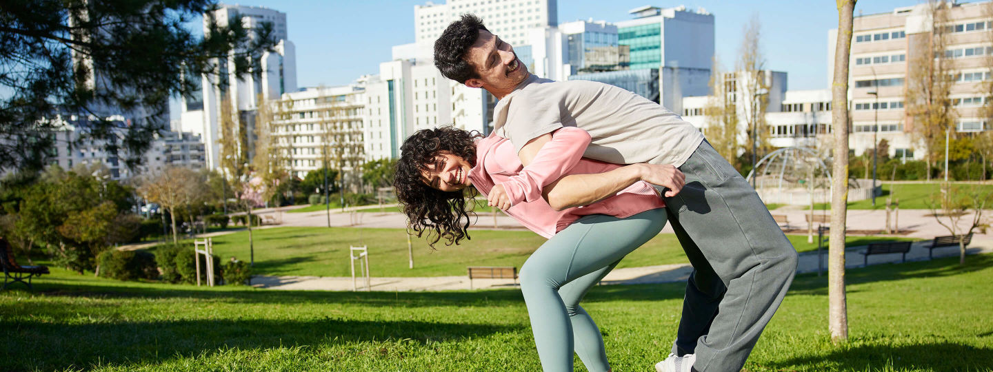 Frau und Mann zusammen im Park haken ihre Arme Rücken an Rücken ein