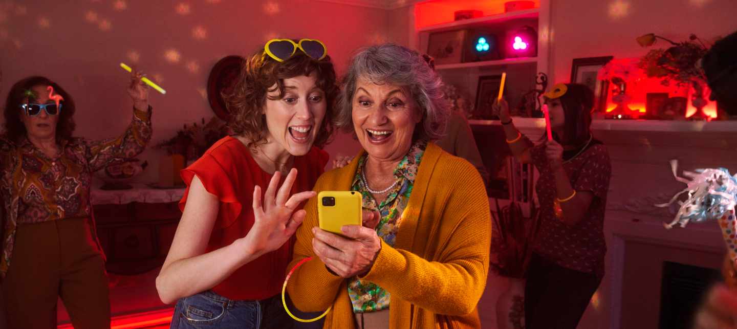 Frauen auf Party empfehlen Yello am Handy