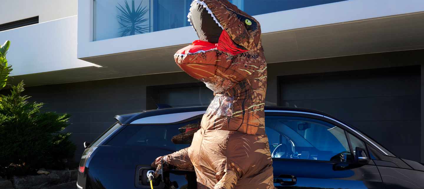 T-Rex Kostüm vor E-Auto