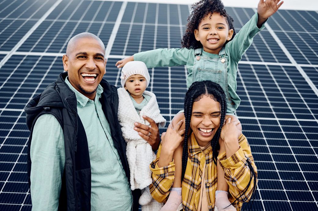 Familie macht zusammen ein Foto vor Solaranlage