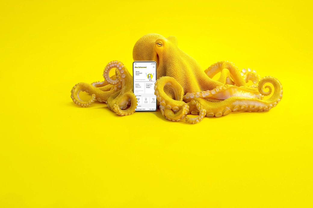 Gelber Oktopus mit einem Smartphone mit Yello App auf dem Bildschirm - KI generiert