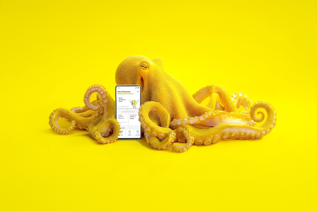Gelber Oktopus mit einem Smartphone mit Yello App auf dem Bildschirm - KI generiert