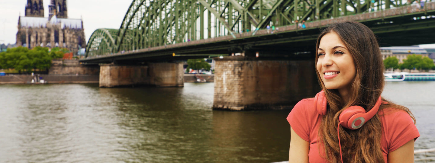 Frau vor der Hohenzollerbrücke am Rhein in Köln