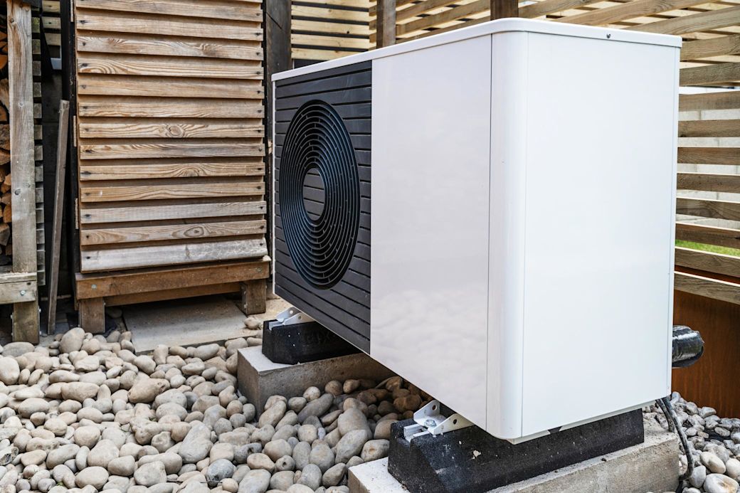 Einheit einer Wärmepumpe vor dem Haus im Unterstand