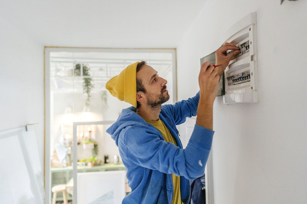 Junger Elektriker arbeitet an einen Sicherungskasten