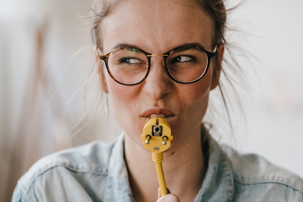 Frau hält ein gelbes Stromkabel in der Hand