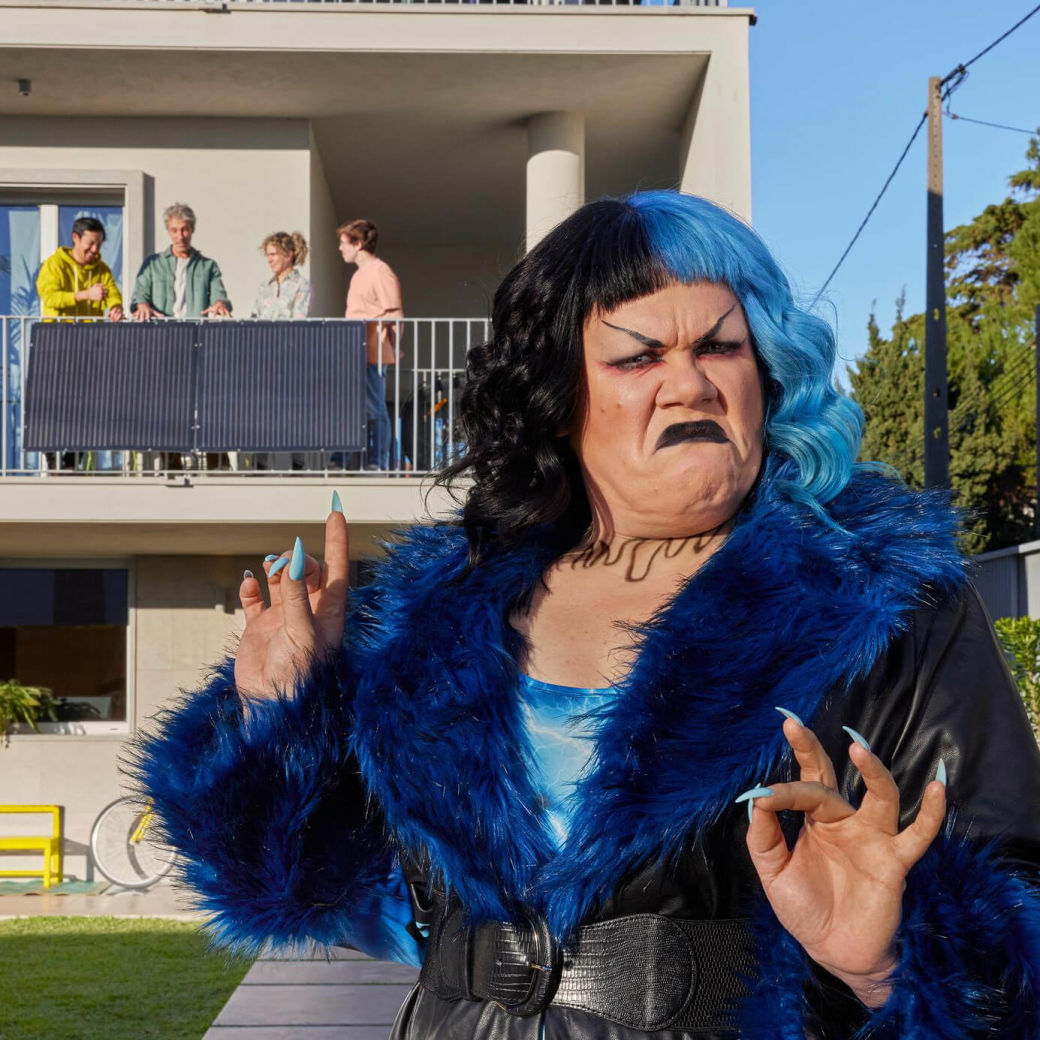 Die Yello Klimakampagne zeigt Frau in Blau vor einem Haus.