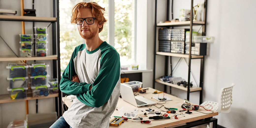 Männlicher IT-Techniker oder Ingenieur mit verschränkten Armen in seinem Home-Office.