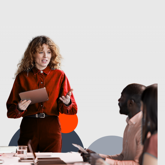 Woman in red blouse holding tablet presenting to colleagues in modern office meeting with white background