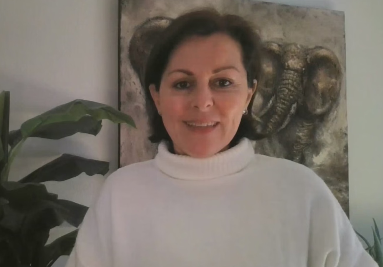 une femme regardant la caméra et portant un chandail blanc
