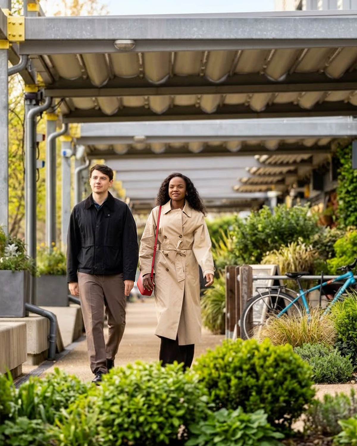 Two employees walking together on a modern work pathway surrounded by green plants and architectural features overhead. (AI assisted Imagery)