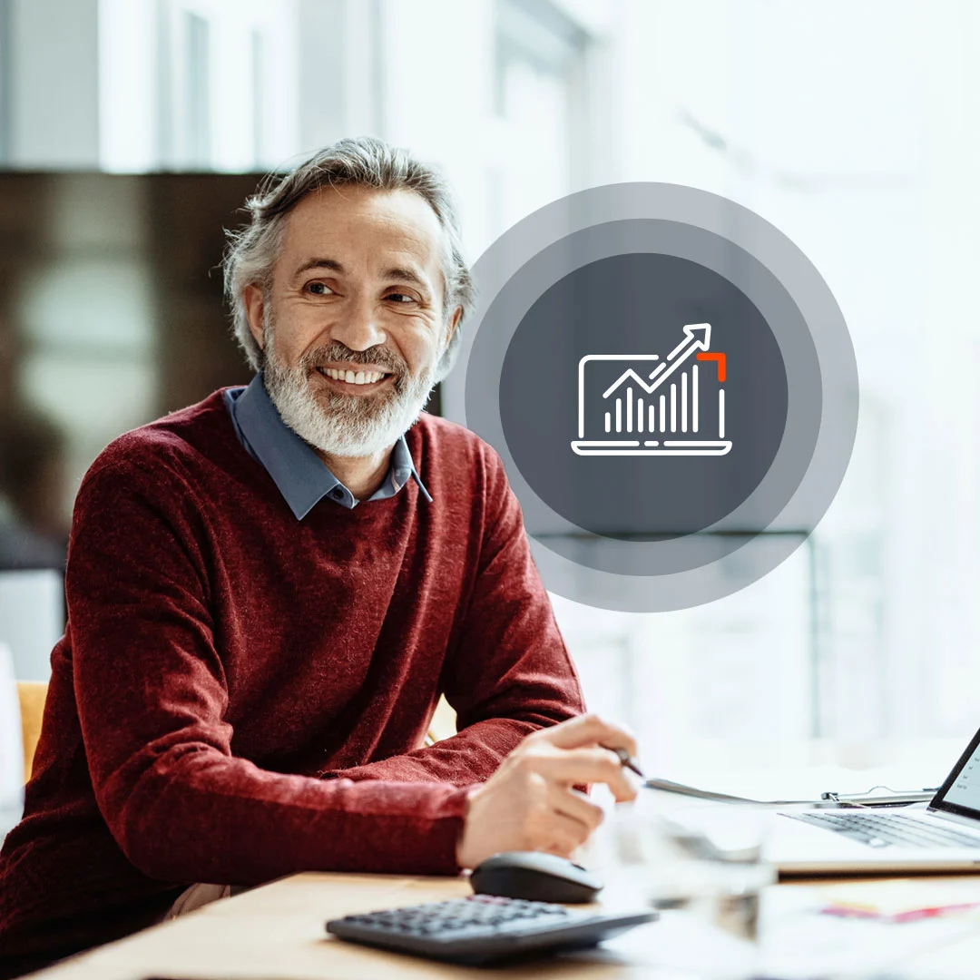 Smiling finance professional in an orange sweater holding a tablet.