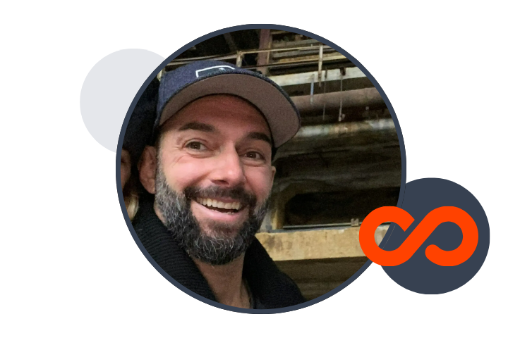 smiling man with a beard and wearing a blue baseball cap, inside a branded circle with Quadient EVP logo