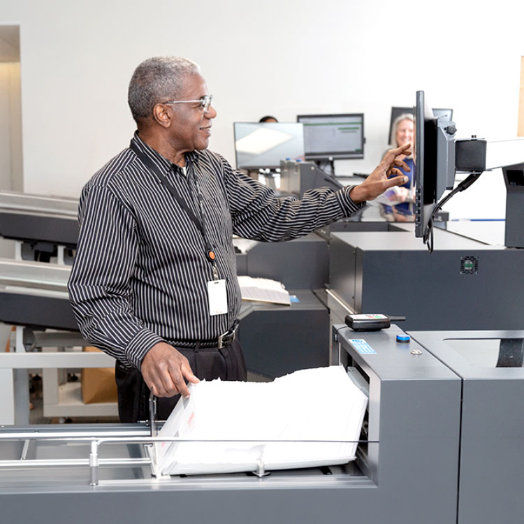 Image of a man using a production mail machine for large volume mailing