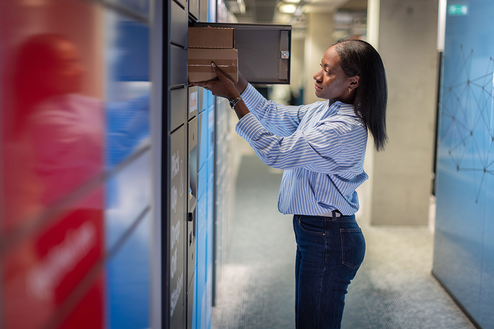 Woman at parcel locker collecting packages from the locker