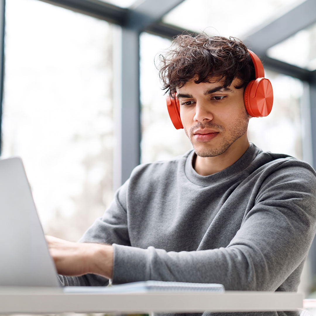 Professional man with orange headphones watching a webinar