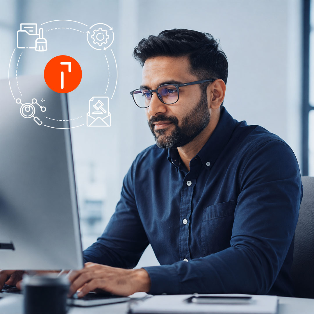 Man in glasses and navy shirt working at computer with digital mail workflow tools icons and logo