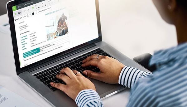 business user editing a customer communication displayed on laptop