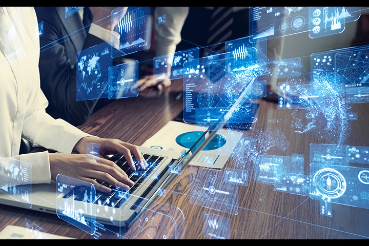 hands working on a computer with graphics of numbers and code in front