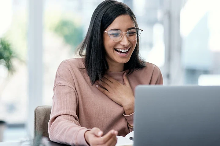 happy woman looking at laptop
