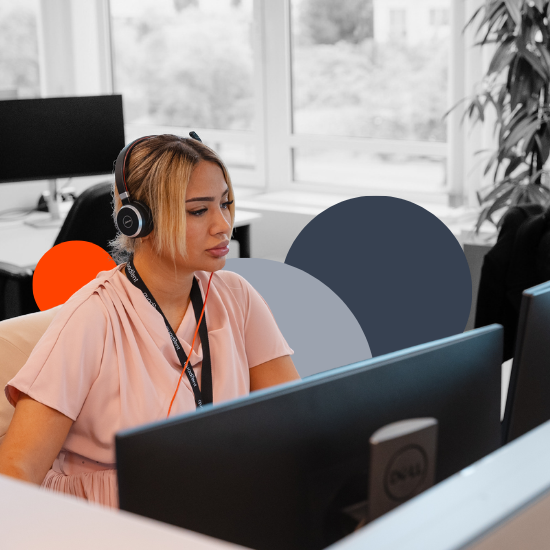 Woman wearing headset working at computer desk in modern office