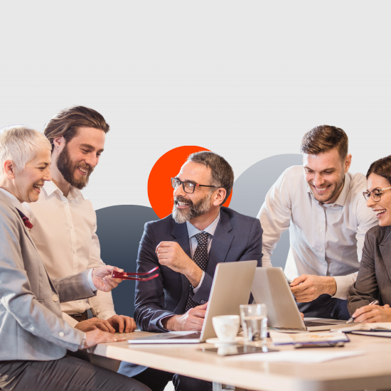 Business team of five professionals collaborating around a conference table with laptops and coffee cups in modern office.