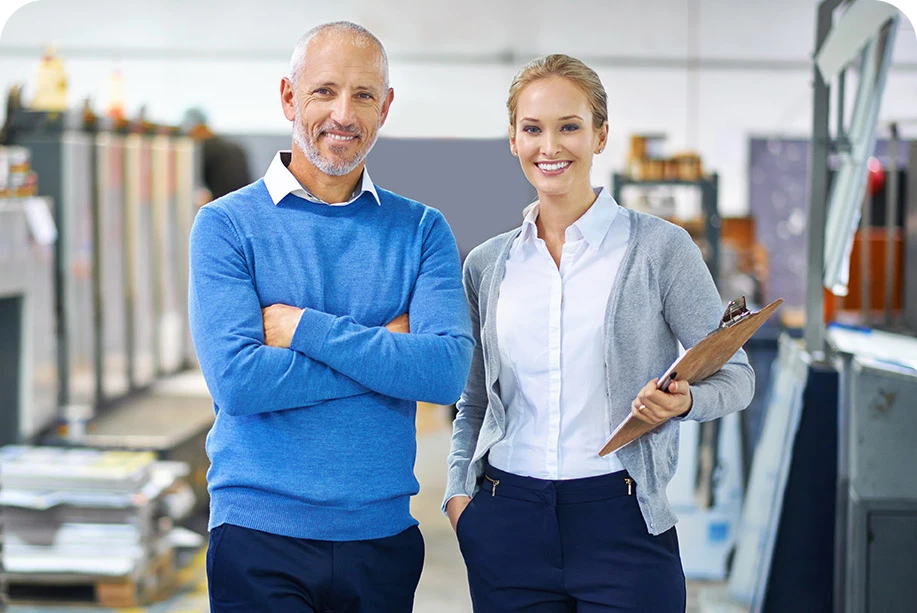 a man and a woman in an office smiling at camera