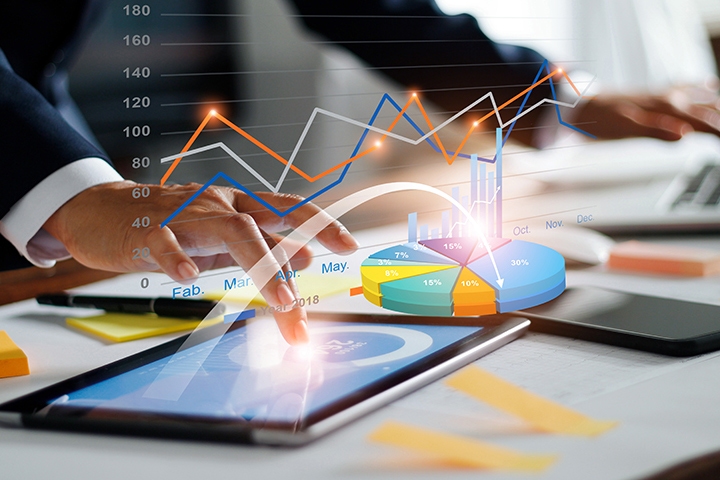 Businessman using tablet and laptop analyzing sales data and economic growth graph chart