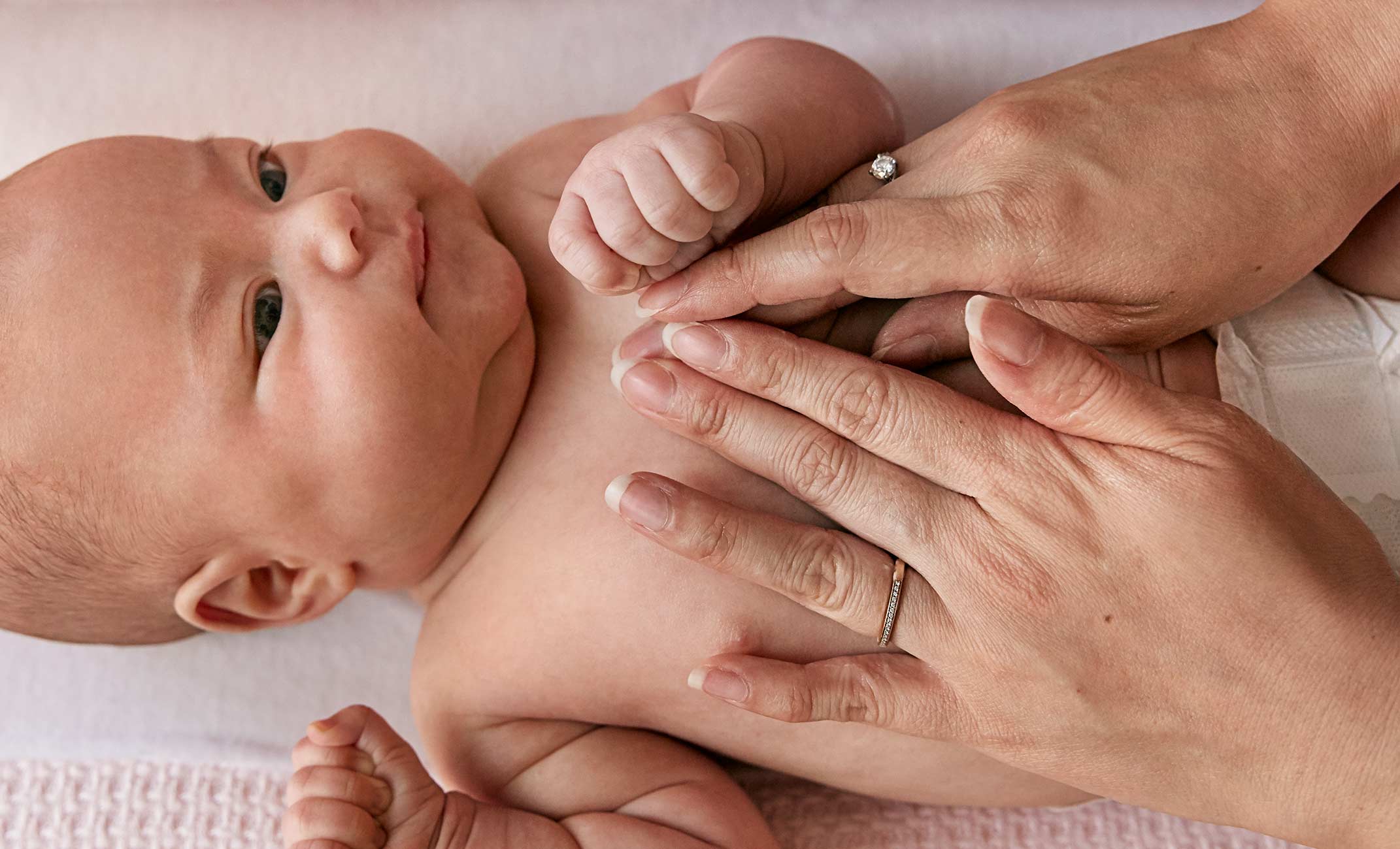 Bebê deitado sendo massageado no tórax