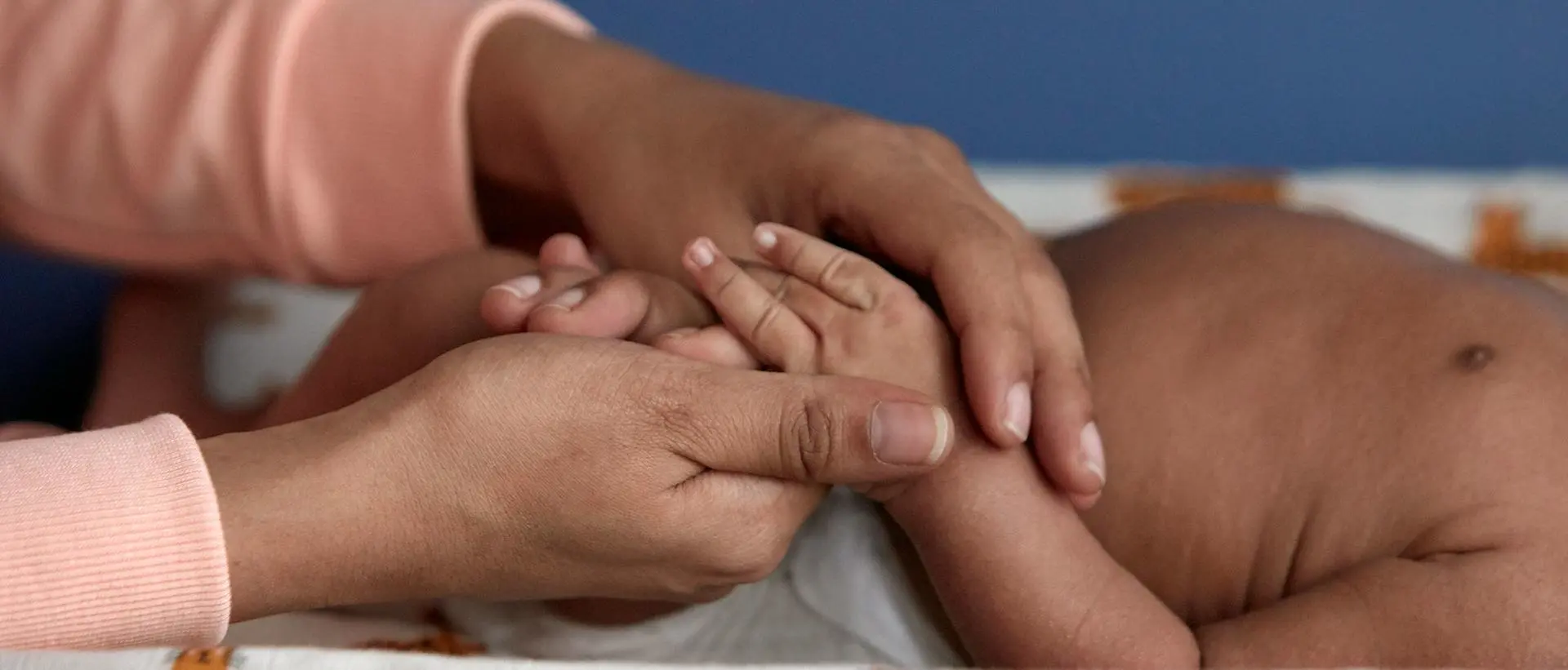 Mulher massageando as mãos do bebê