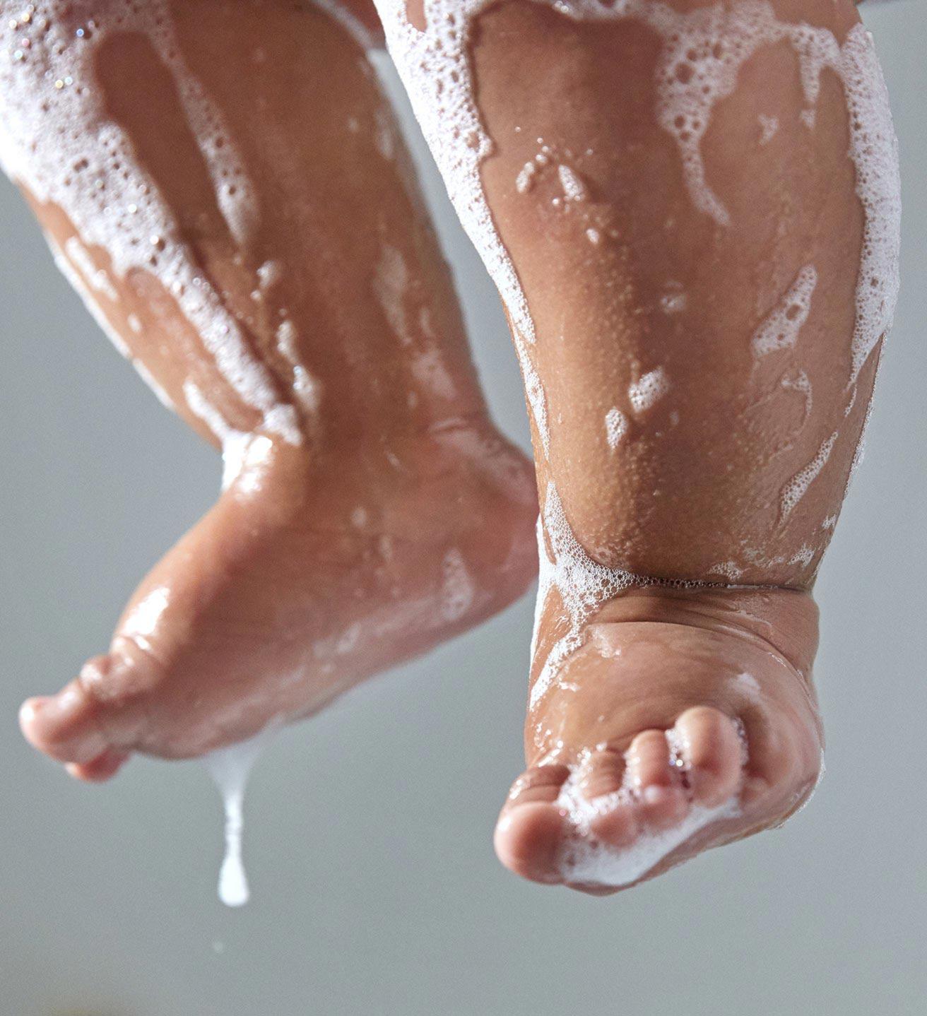 Pés do bebê com espuma durante o banho