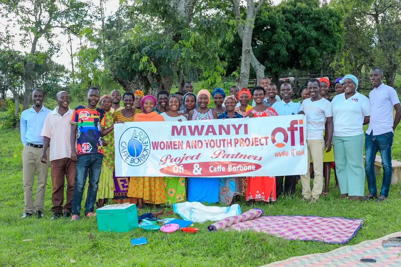 Group photo holding a banner for MWANYI Women and Youth Project