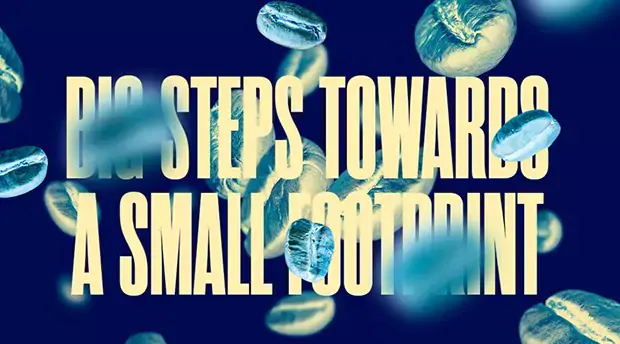 Image with text saying: big steps towards a small footprint on a blue background with falling coffee beans