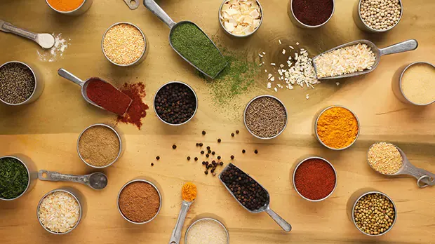 Above shot of various scoops filled with different types of spices