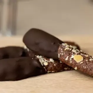 Three chocolate dessert sticks with one side covered in chocolate sauce