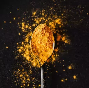 A spoon filled with spice tumeric