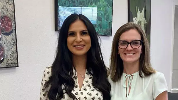 Two women standing next to each other and smiling