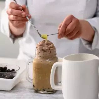 Chef decorating a beverage topped with chocolate cream